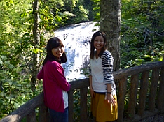 滝をバックに写真撮影する女性2人の写真
