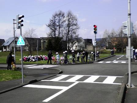 小学生に横断歩道での自転車の渡り方を教えている交通安全児童指導員の方の写真