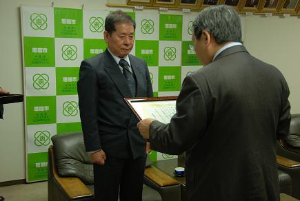 柏井康彦さんが市長から表彰状を授与されている写真