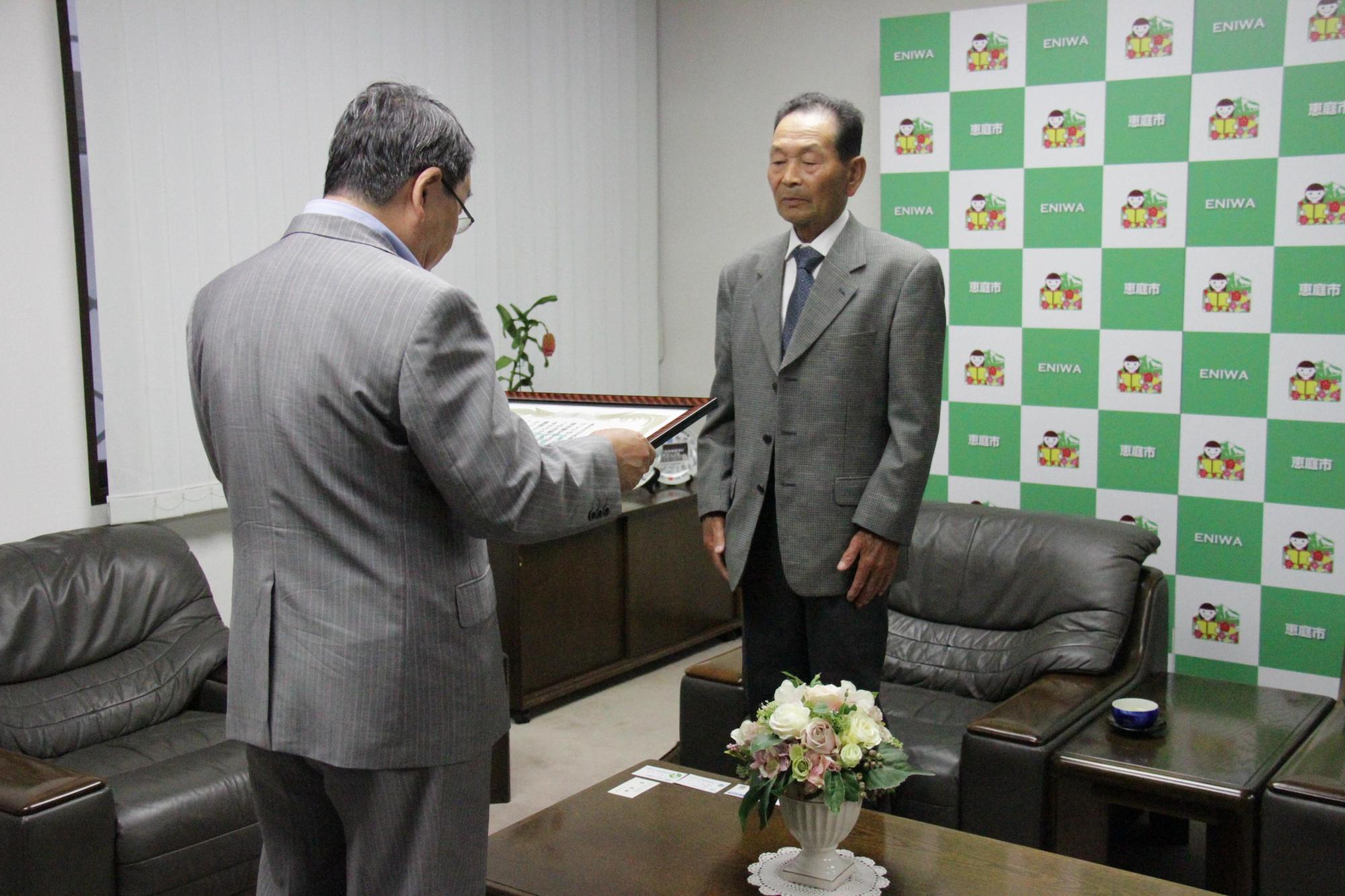 小林功一さんが市長から表彰状を授与されている写真