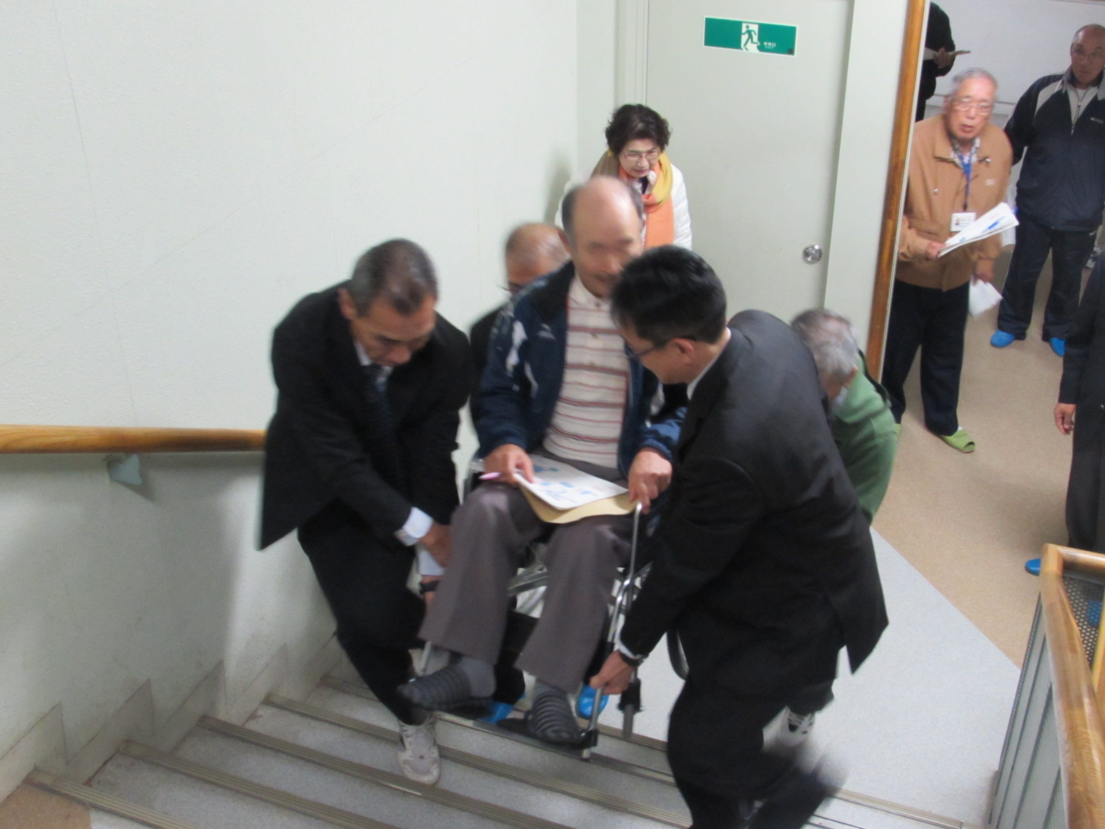 学校の廊下の移動を車椅子で確認する参加者の写真