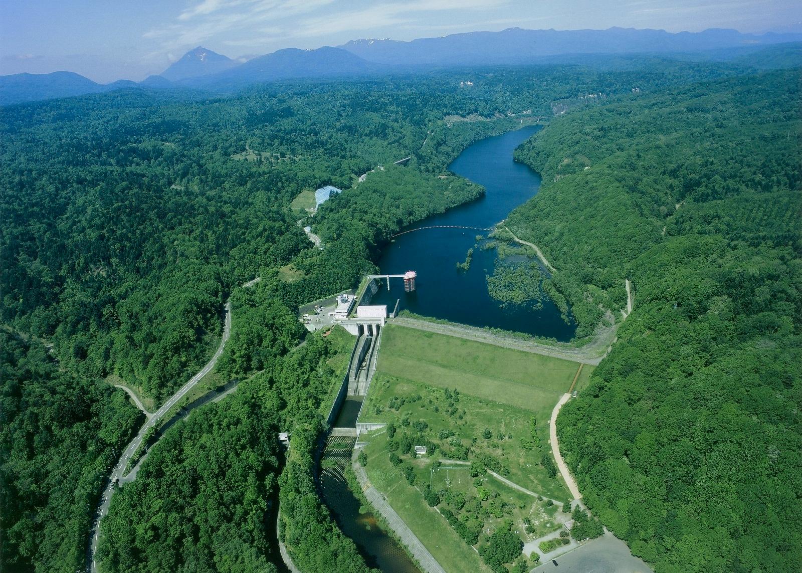 緑に囲まれた漁川ダムの航空写真
