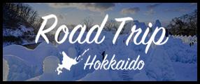 雪を背景にロードトリップ北海道と書かれたロゴの写真