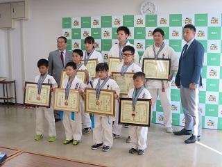 極真館恵庭道場に所属する小中学生、高校生の選手9人と原田市長が記念撮影している写真