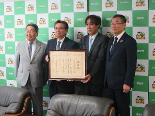 野旭小学校の校長先生と教頭先生が受賞賞状を手に原田市長と記念撮影している写真