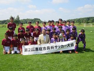少年サッカーチーム藤枝トレセンのメンバーと芝生の上に集まる原田市長の記念写真