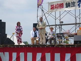 会場のステージの上で挨拶をする原田市長の写真