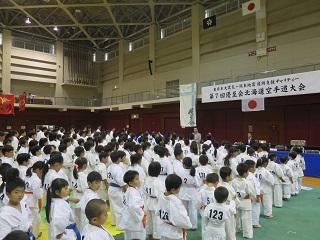 総合体育館で挨拶する原田市長と整列している出場選手の写真