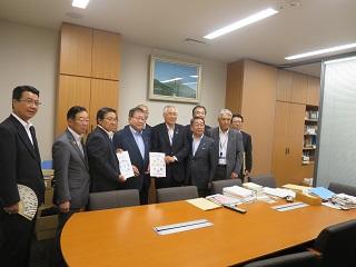 原田市長と関係者らが書類を持って並んでいる写真