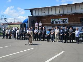 会場となったJA道央の駐車場で挨拶をする原田市長の写真