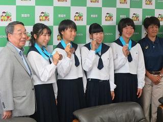 原田市長と銅メダルを掲げている選手4人の記念写真