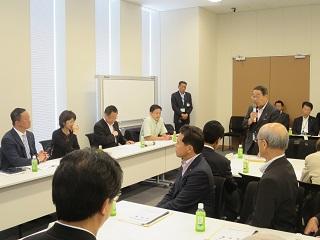 議会で発言する原田市長と出席者の写真