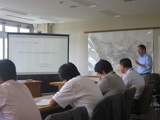 プロジェクターを使い恵庭市のまちづくりについて説明する原田市長と出席者の写真