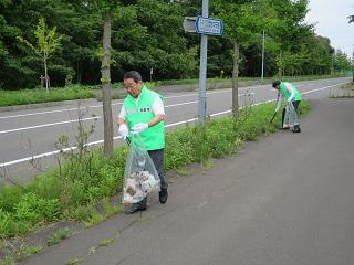 市職員とともに歩道のごみ拾いをする原田市長の写真