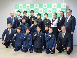 出場選手と記念撮影する原田市長の写真