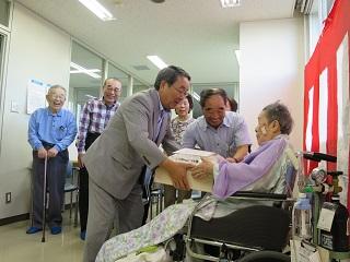 高齢者に記念品を手渡す原田市長の写真