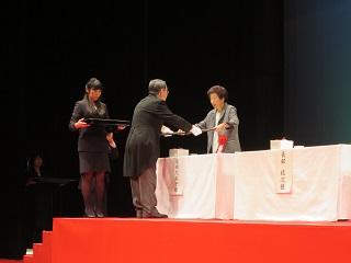 「恵庭市功労者表彰式」にて表彰状を手渡す原田市長の写真