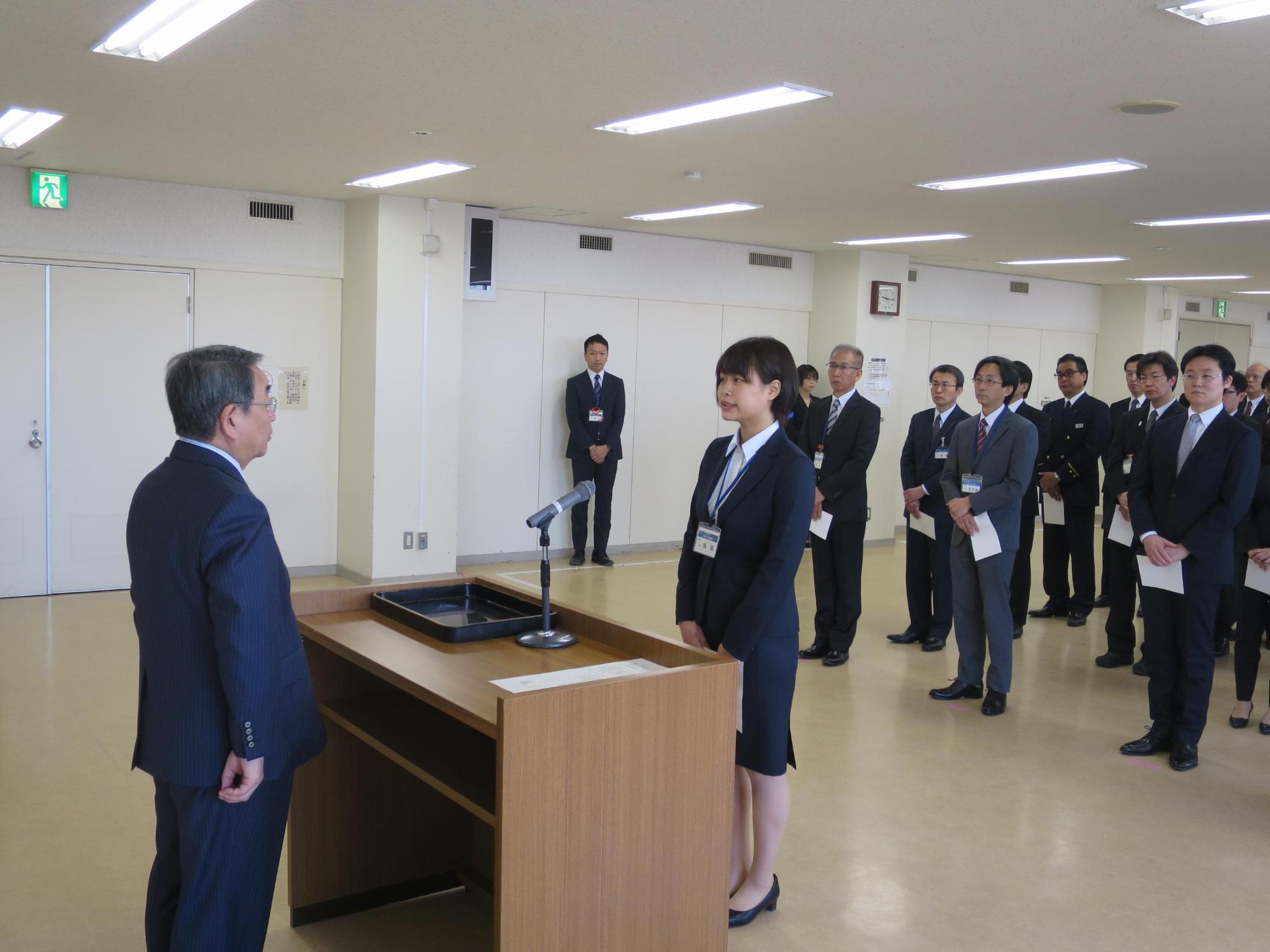 原田市長から職員人事異動辞令書を交付している写真