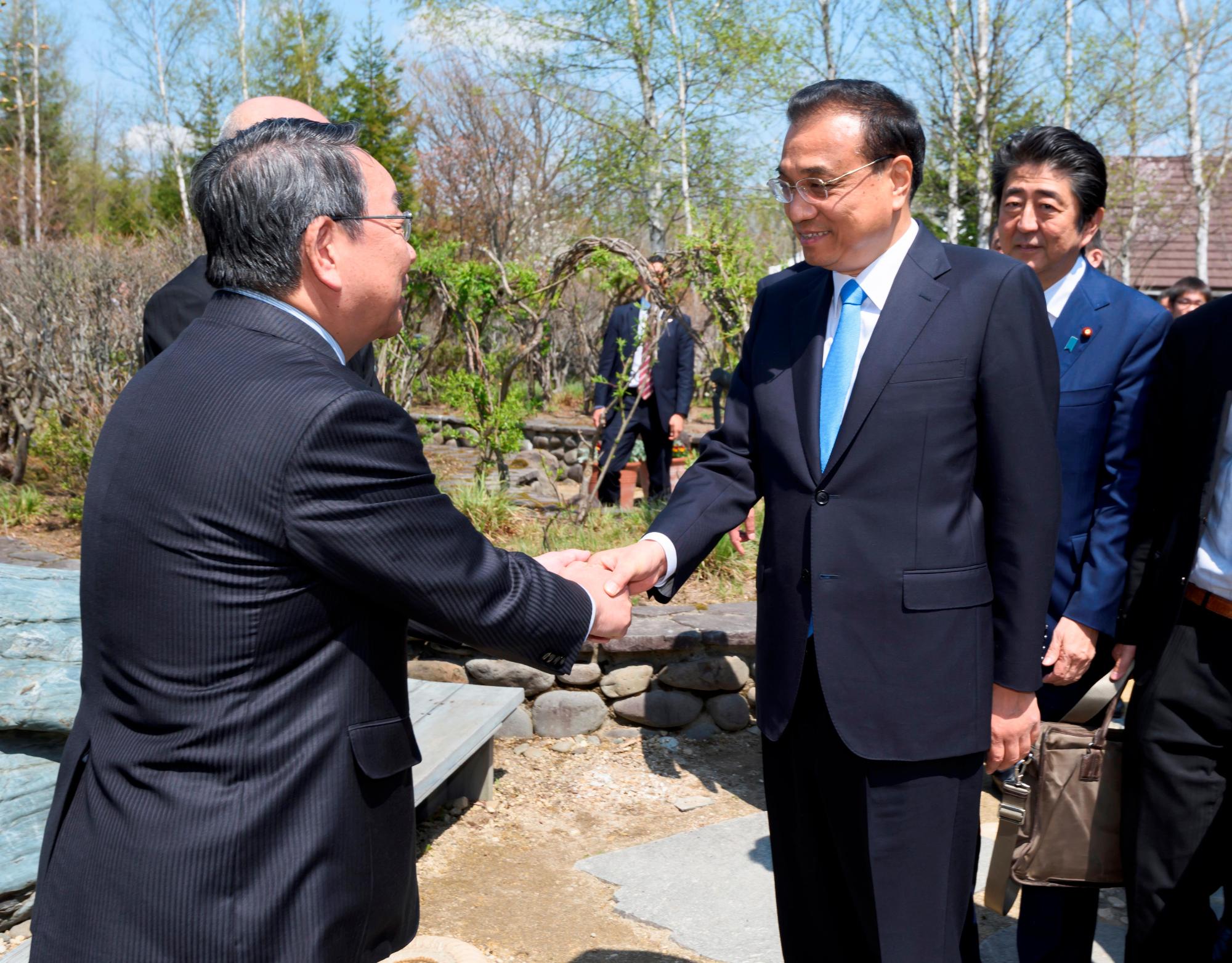 中国の李克強首相と握手をしている原田市長の写真