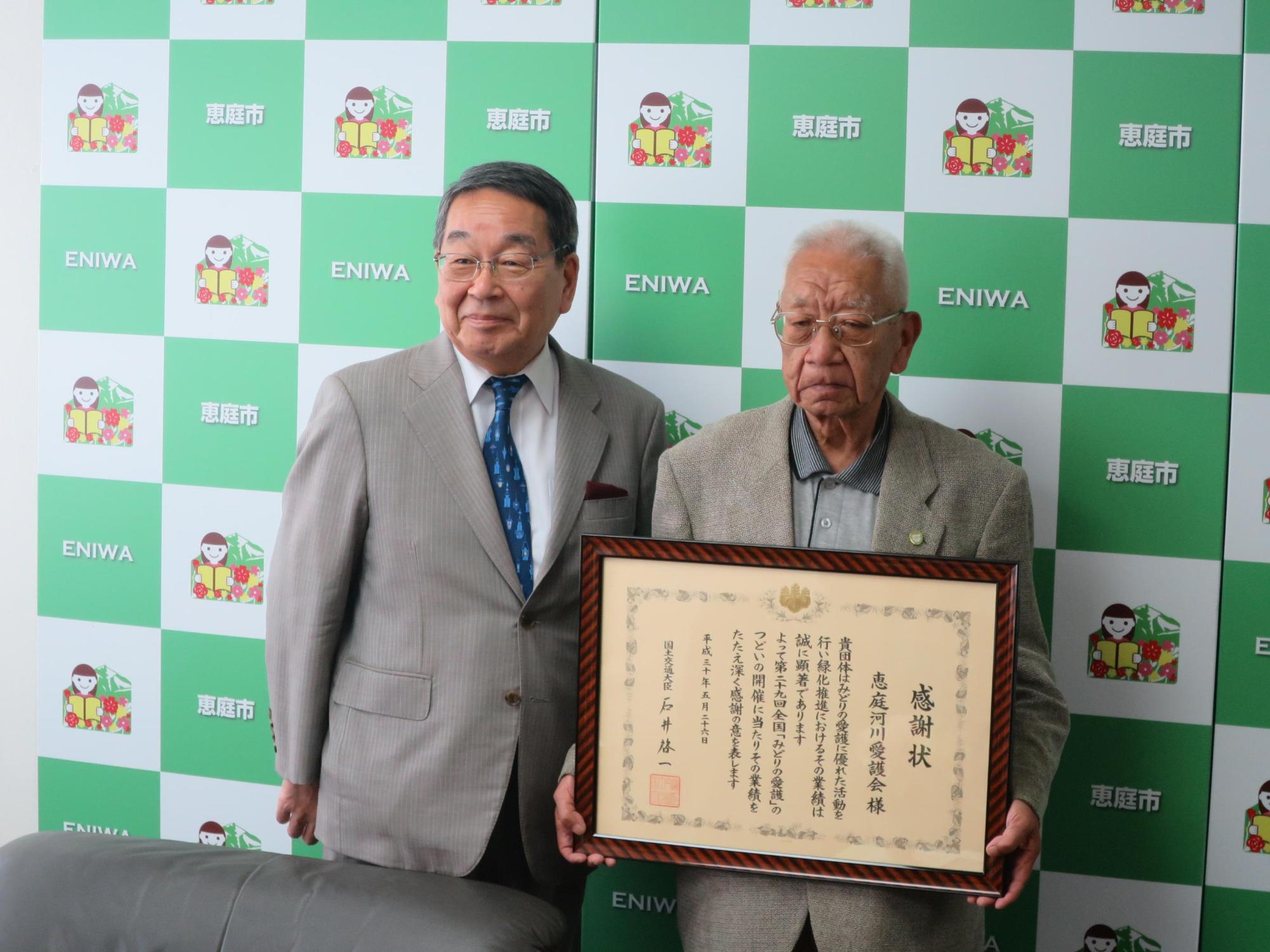 功労者国土交通大臣表彰を受賞された恵庭河川愛護会の三浦会長と原田市長が記念撮影している写真