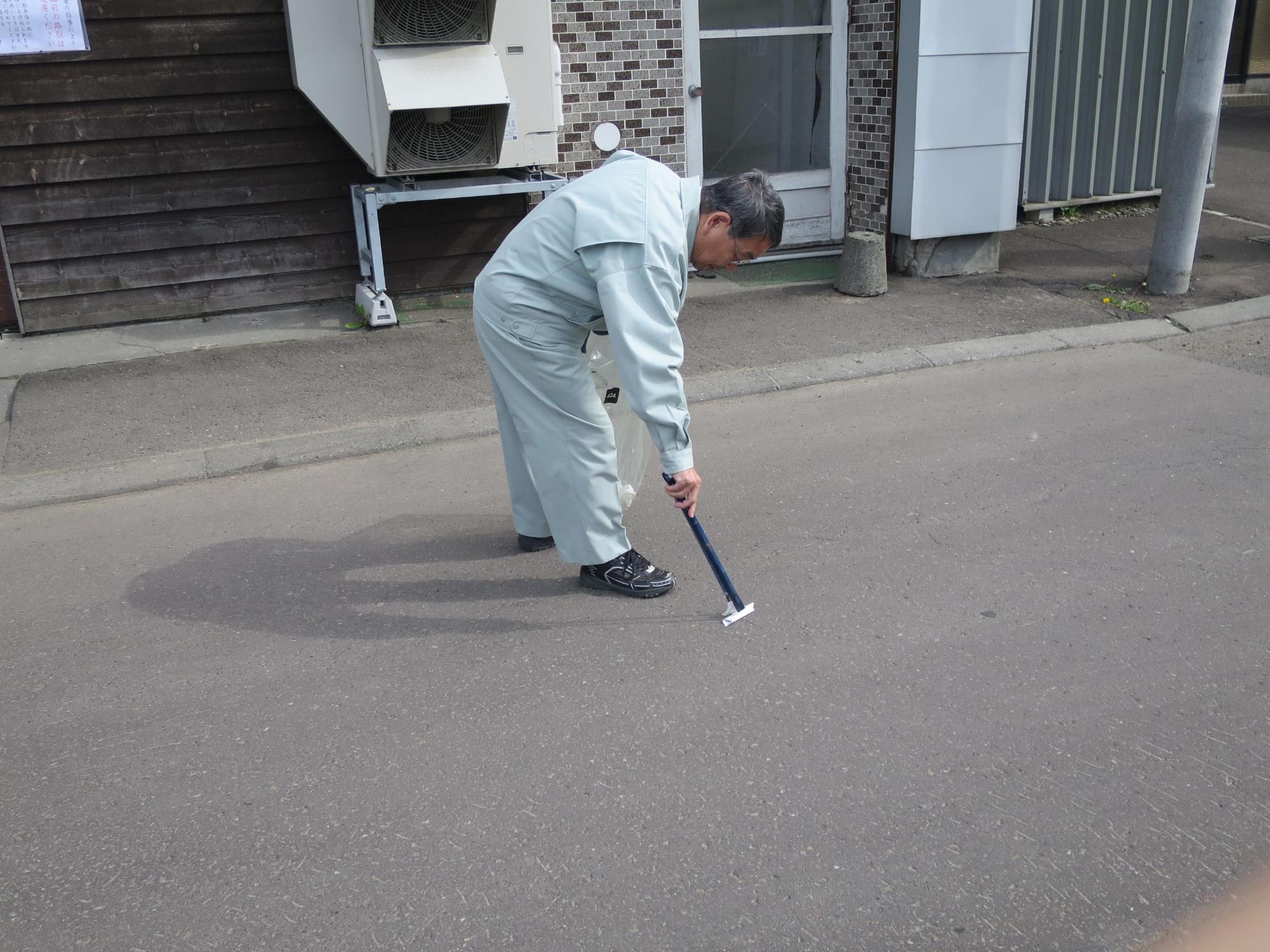 参加者とともに清掃活動をしている原田市長の写真