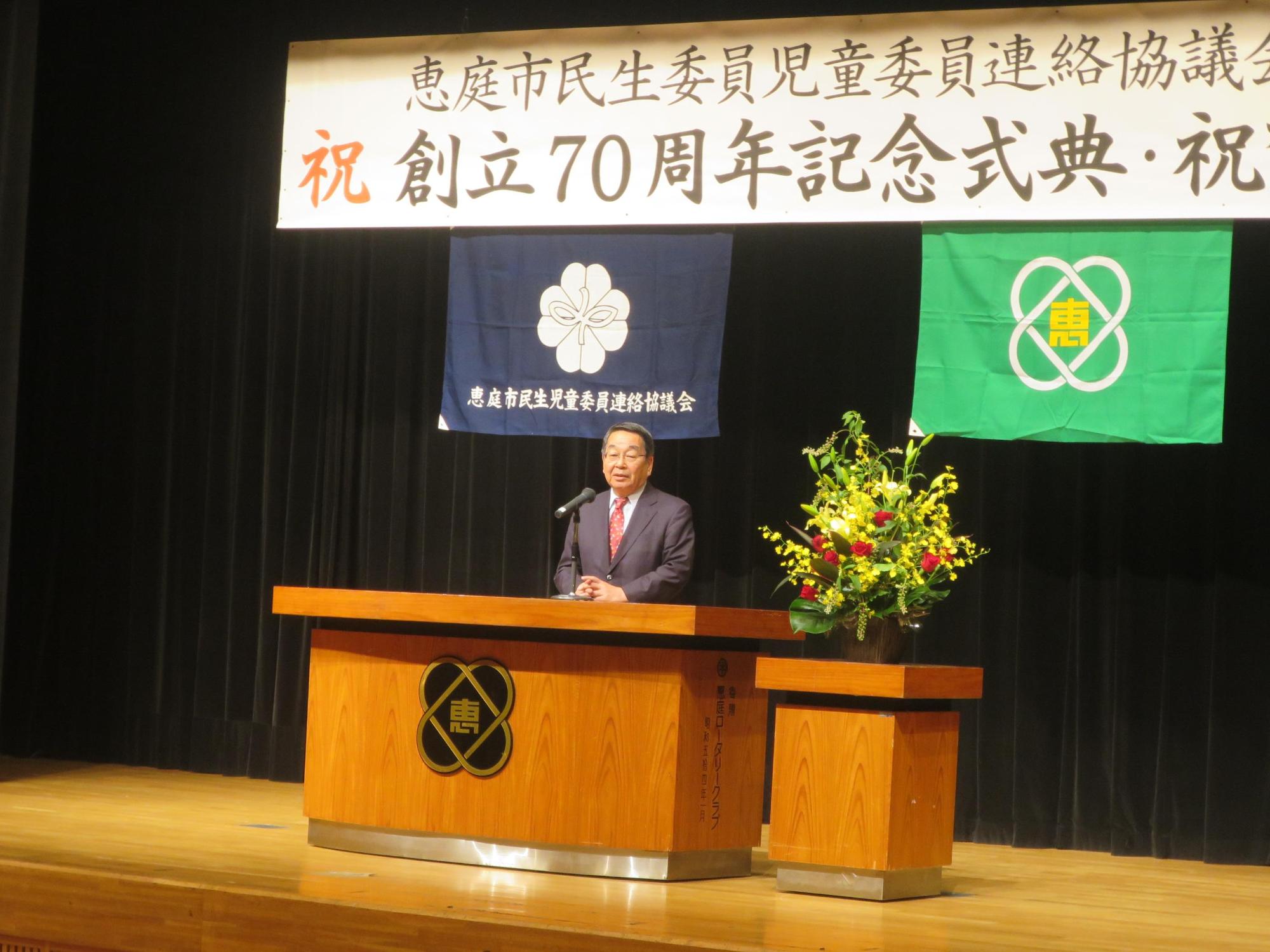 式典会場の檀上より祝辞を述べる原田市長の写真