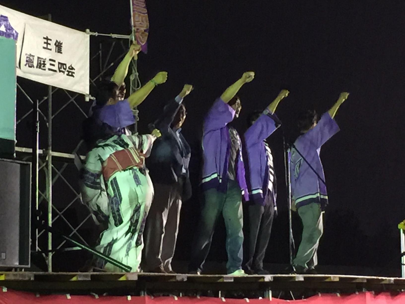 花火大会関係者と一緒に片手を掲げる原田市長の写真