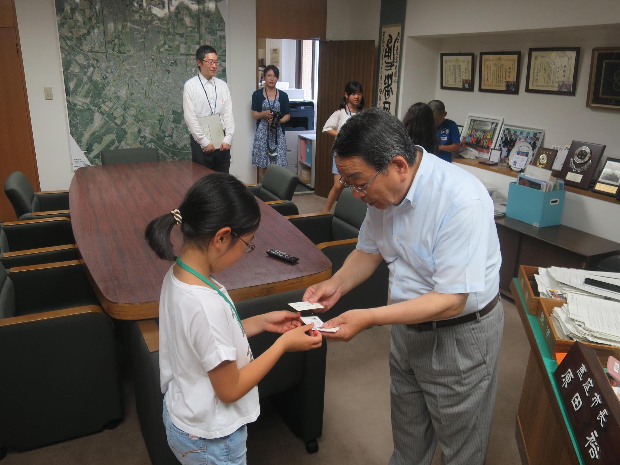 親の職場見学にて子どもたちが原田市長と名刺交換をしている写真1