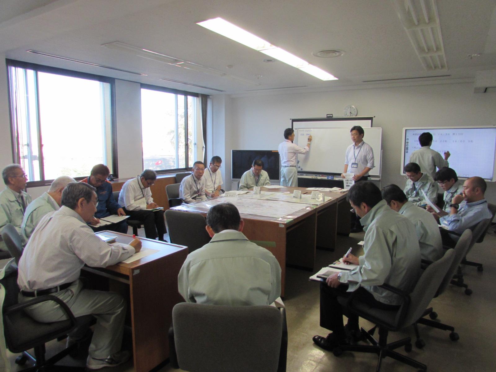 北海道胆振東部地震に伴いホワイトボードを使って災害の対応を話し合っている写真1