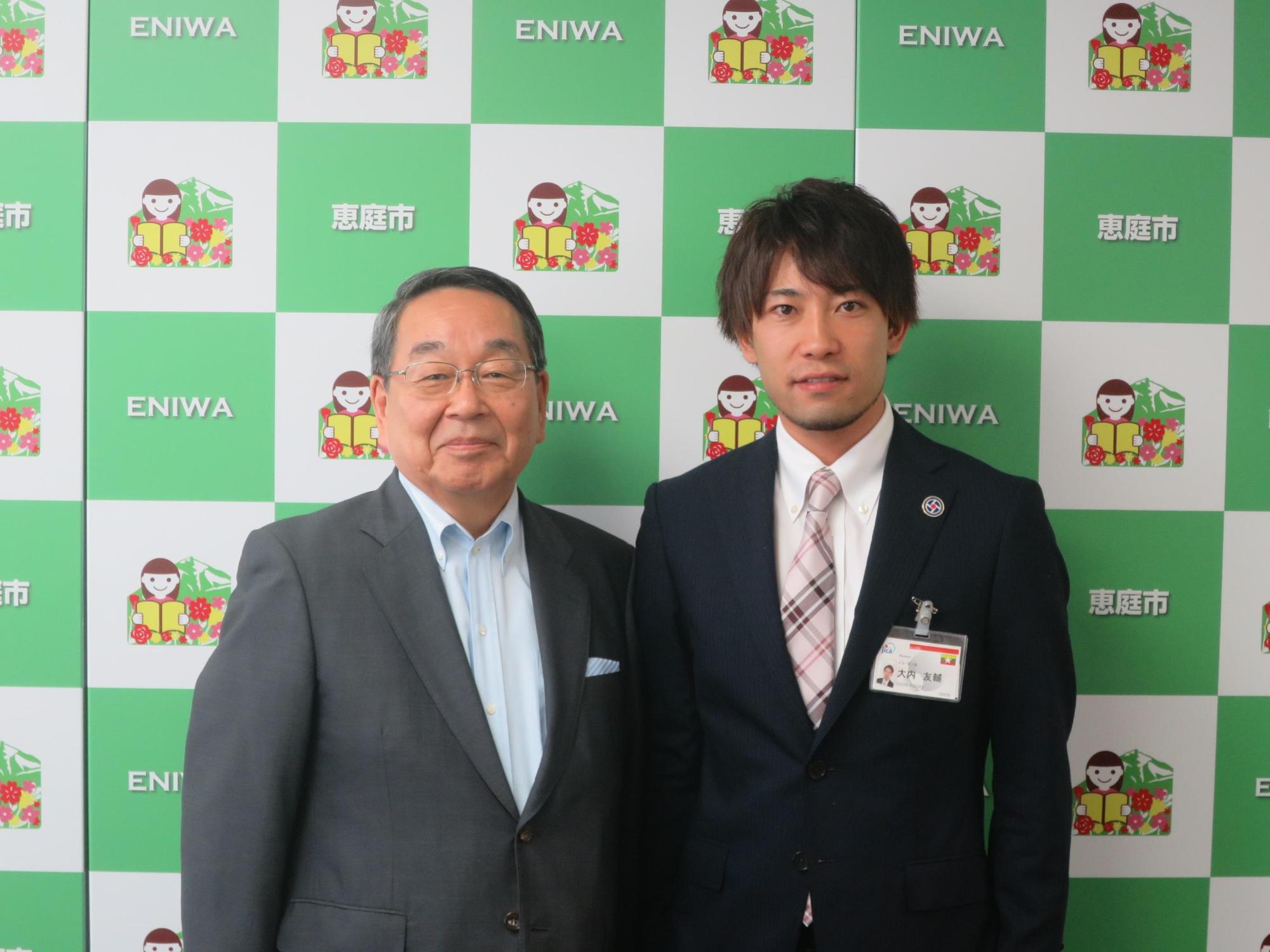 青年海外協力隊員の大内さんと原田市長が記念撮影している写真