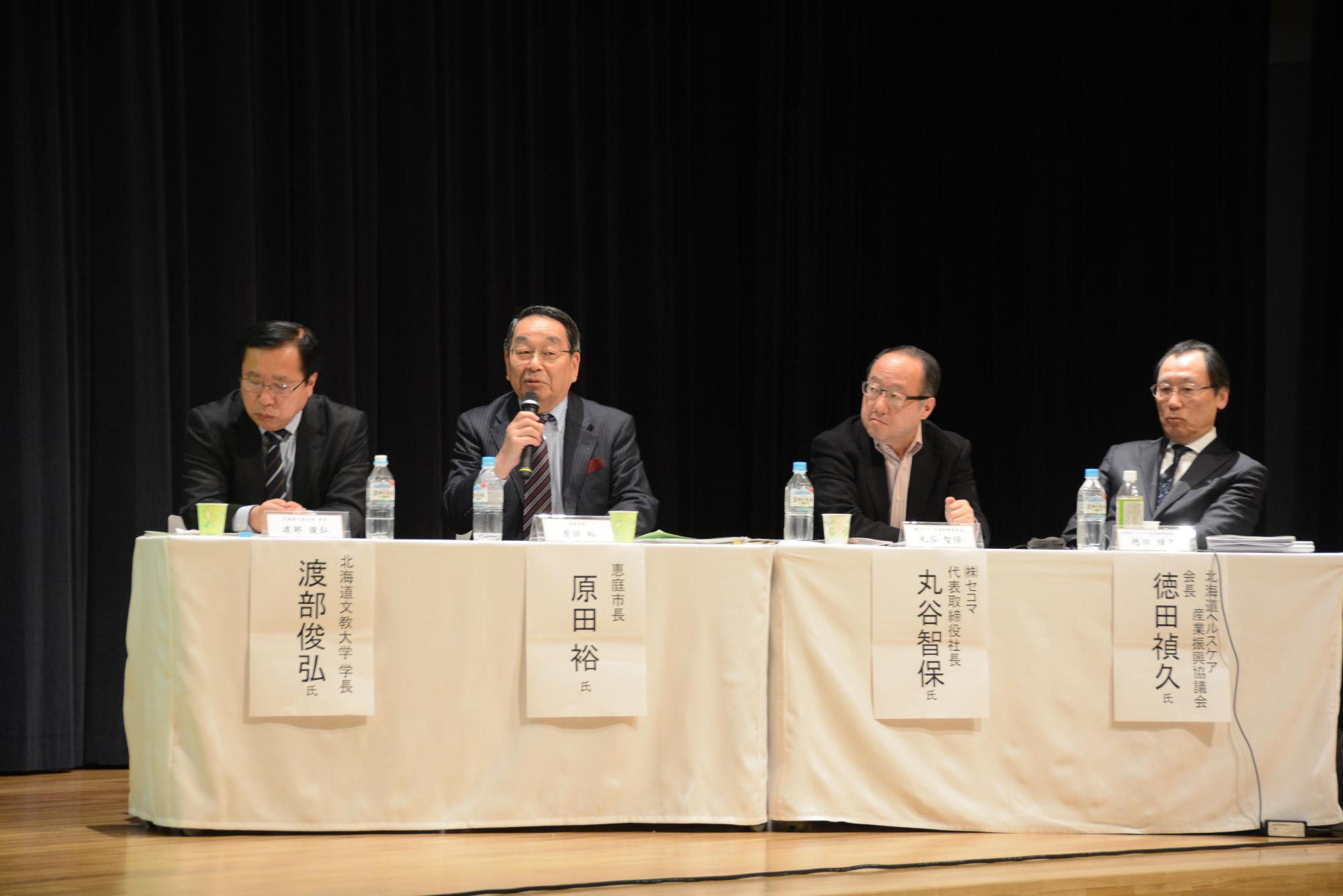 地域コミュニティーを支える産官学連携シンポジウムで発言する原田市長