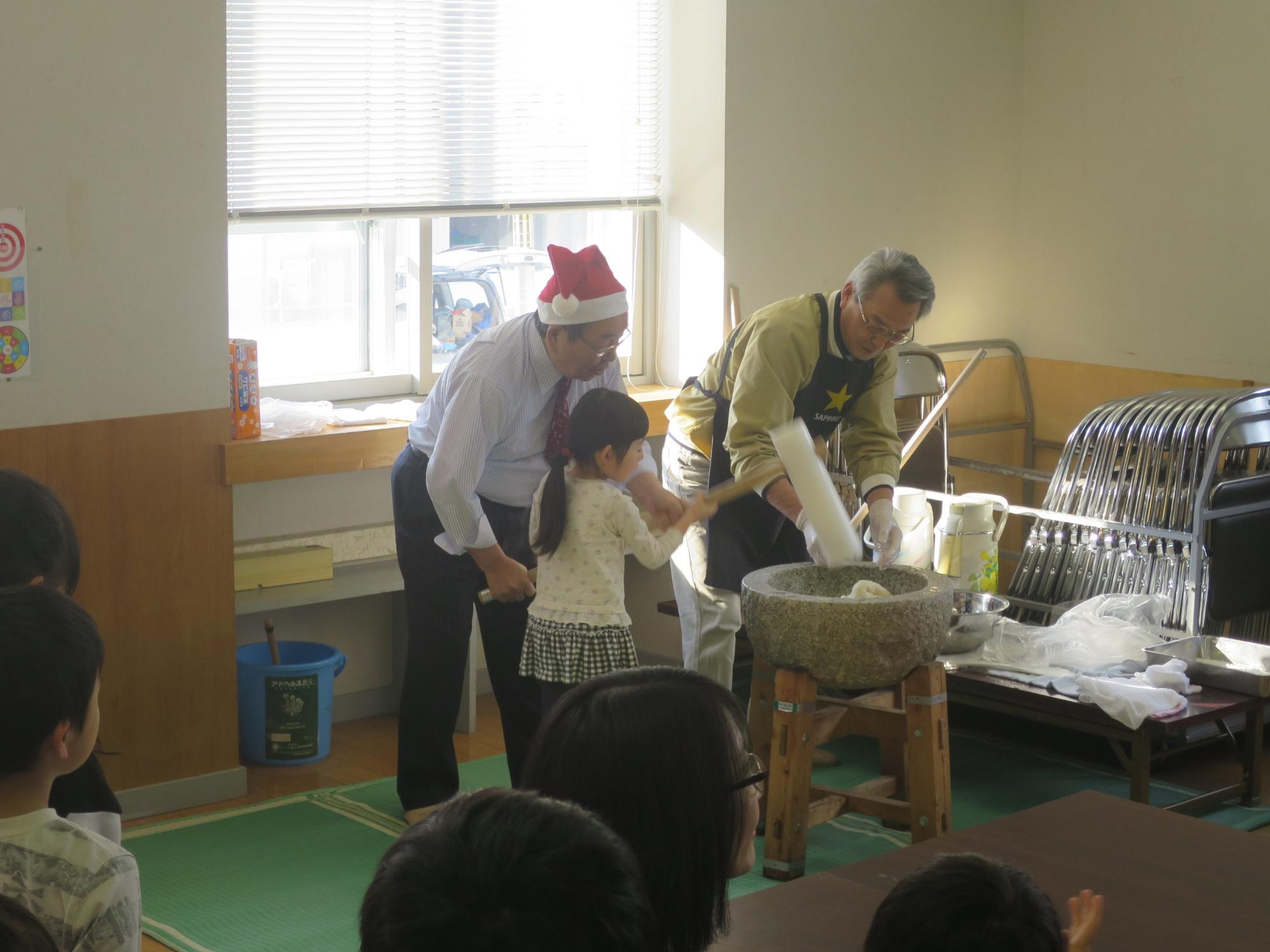 恵み野北町内会・餅つき大会で子どもと一緒に餅をつく原田市長