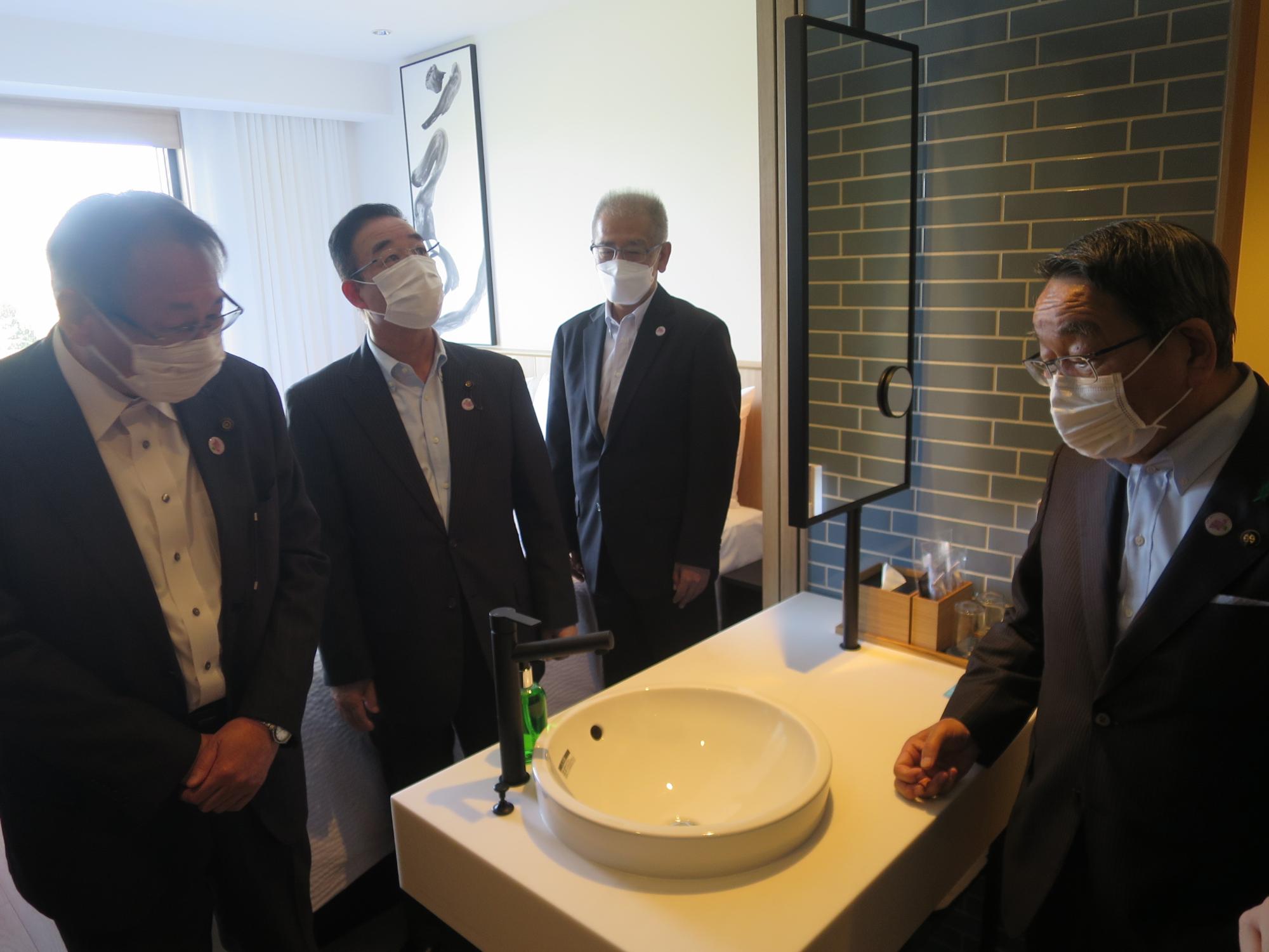部屋の洗面所を視察する原田市長