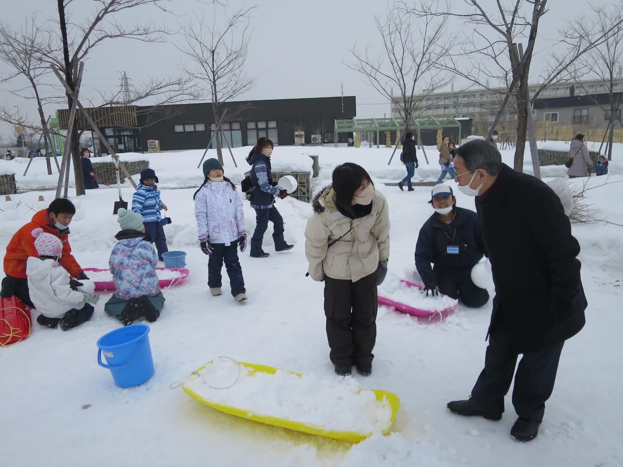 雪だるま作りを見る原田市長