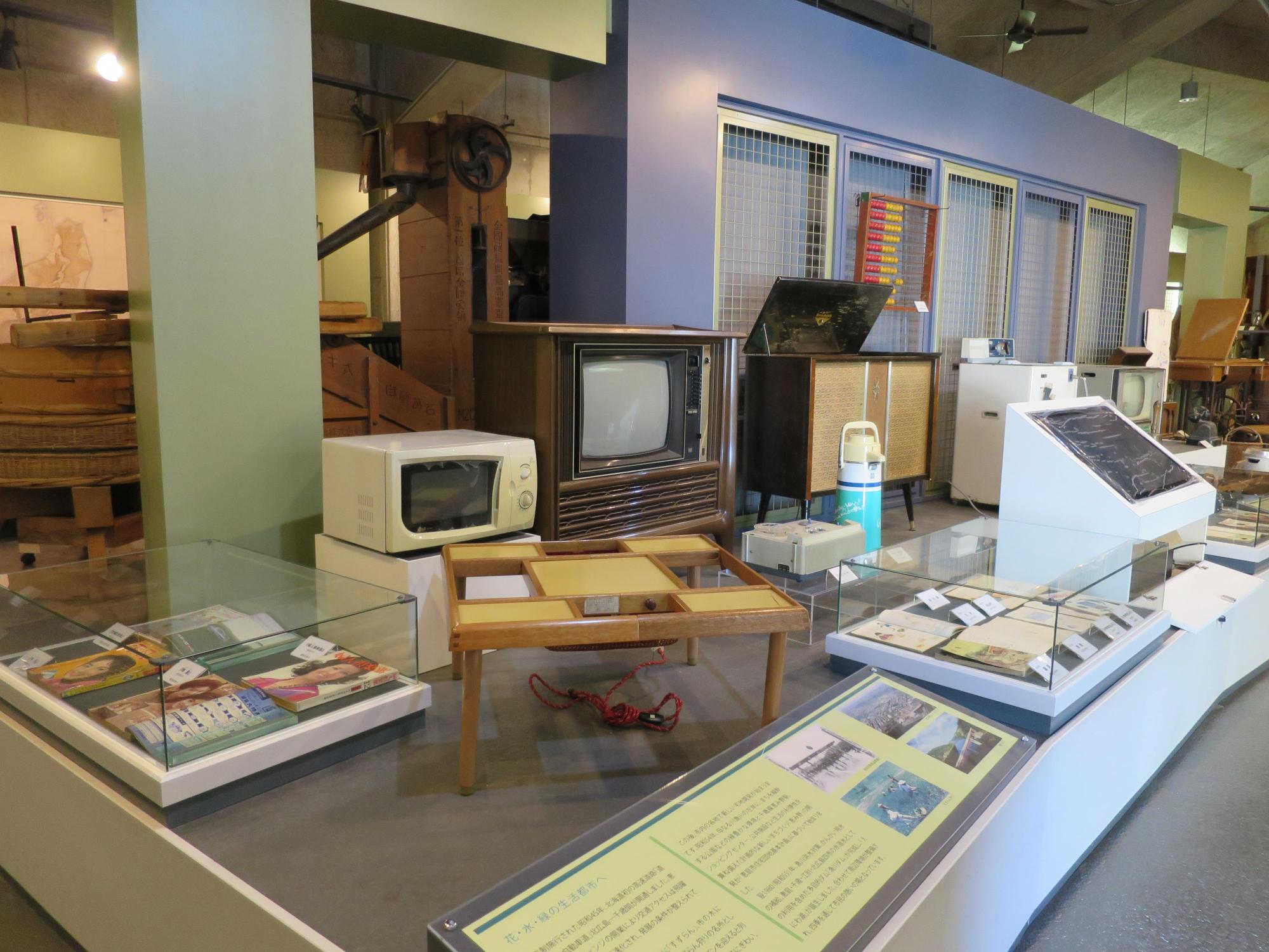 昭和40年代に使用されたテレビや電子レンジなどの生活用具が展示された写真